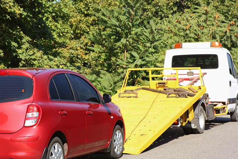 California ReLeaf Car Donation - red vehicle being towed away
